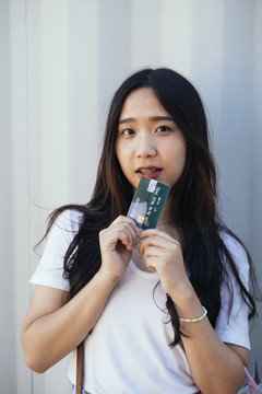 黑色长发女孩展示她用于网上购物的信用卡。