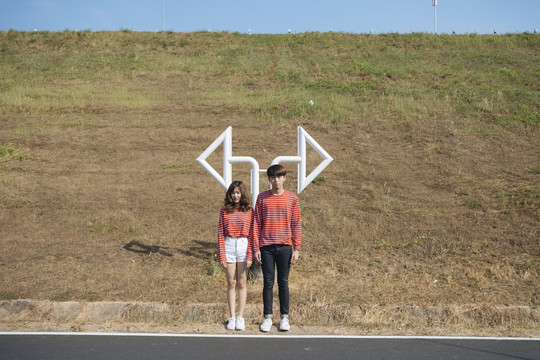 一对身穿红色配套t恤的年轻夫妇站在两个边坡旁。