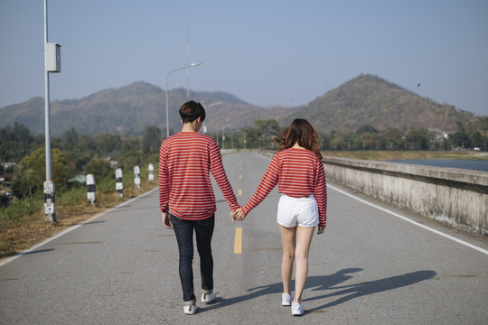一对年轻夫妇在去山景城的路上手牵着手。