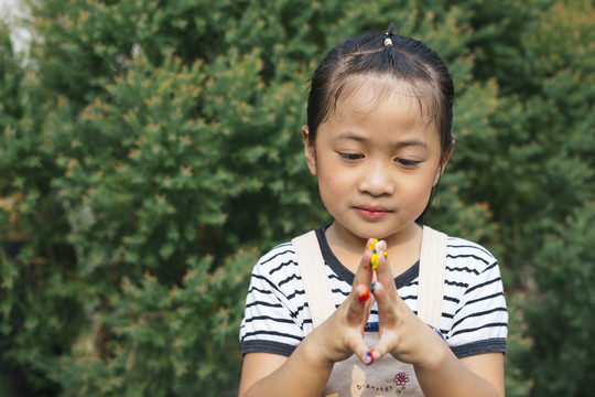可爱的亚洲小女孩在花园里用手玩彩绘。