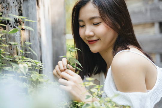 年轻美丽的亚洲女人的肖像在白色的衣服上自然。带着幸福的表情微笑。