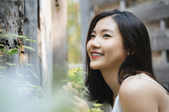 年轻美丽的亚洲女人的肖像在白色的衣服上自然。带着幸福的表情微笑。