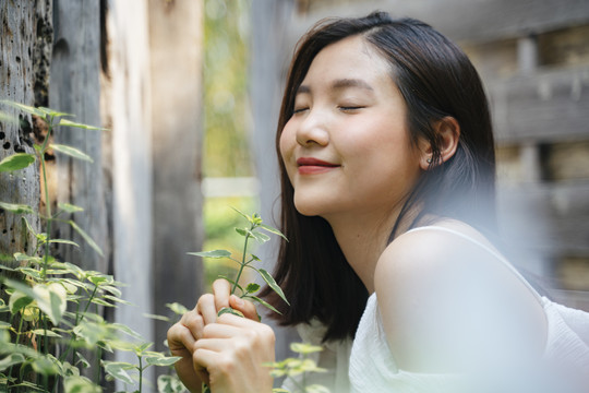 年轻美丽的亚洲女人的肖像在白色的衣服上自然。带着幸福的表情微笑。