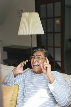 一位白发老人很高兴他能通过智能手机和他的孙子们交谈。