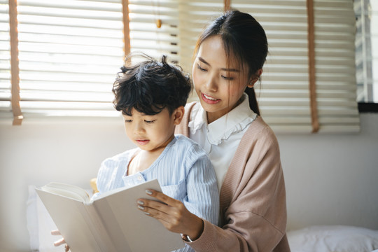 妈妈在卧室里给儿子讲故事。