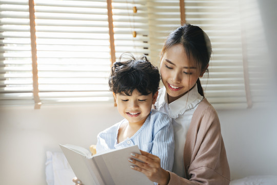 妈妈在卧室里给儿子讲故事。