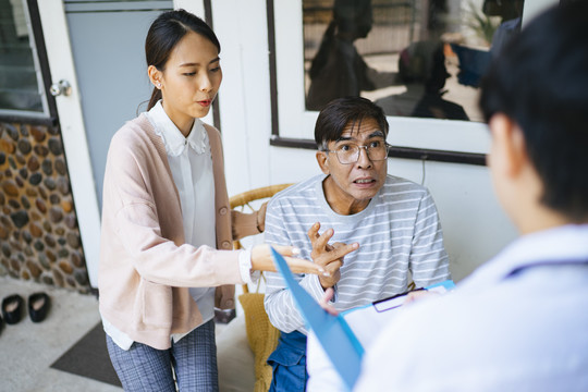 一位白发老人和他的女儿在家访时告诉医生他的病情。