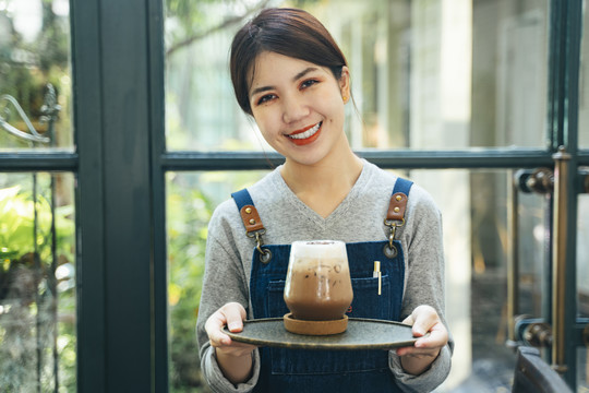 咖啡厅咖啡厅，围裙里的咖啡师侍女在端冰镇咖啡。