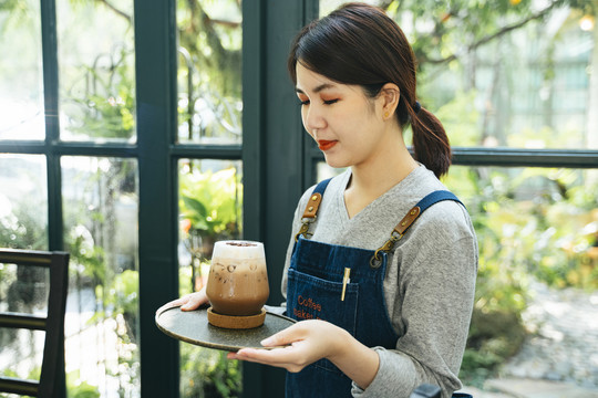 咖啡厅咖啡厅，围裙里的咖啡师侍女在端冰镇咖啡。