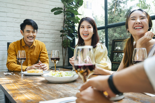 亚泰人喜欢在餐馆里一起吃饭。人们在午餐时间用酒在桌子上吃食物。