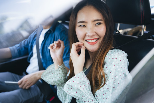 美丽的亚泰女人和她的朋友在车里旅行。