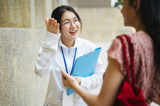 开朗的亚洲导游女士给旅行者指路。