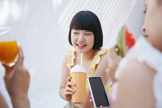 可爱短发的亚洲女人喜欢和朋友在夏日派对上喝酒。