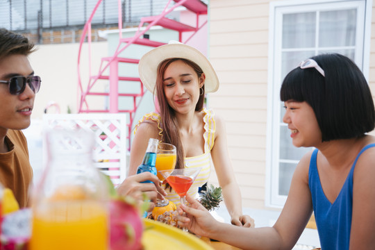 美丽的亚洲女人喜欢在夏天和人们在热带酒吧喝酒。