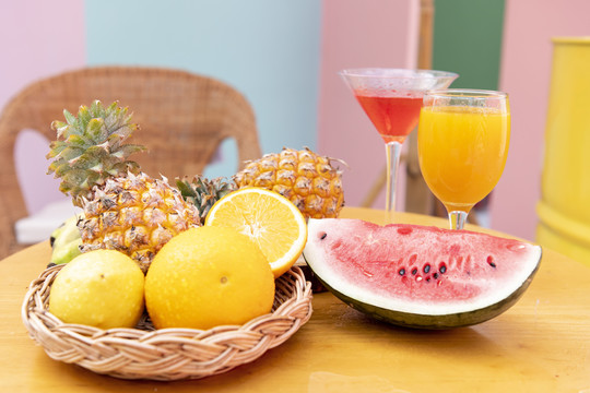 桌上有热带水果和果汁鸡尾酒-橙子，菠萝，西瓜，柠檬。健康水果。夏日派对。