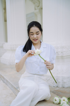 黑马尾姑娘坐在寺院的地板上，折好莲花瓣，准备送给和尚。
