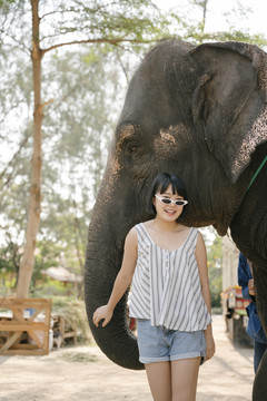 生态旅游-美丽的亚泰女人站在大象面前。