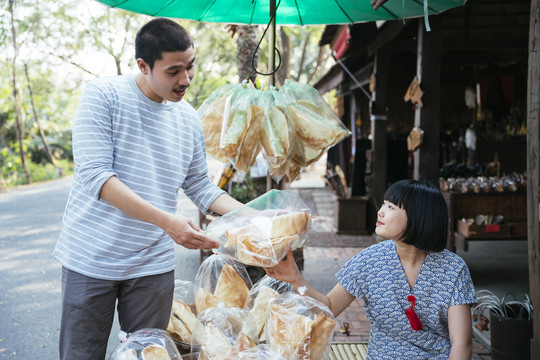 生态旅游——游客在街市上从当地可爱的小贩那里买虾、脆饼干。