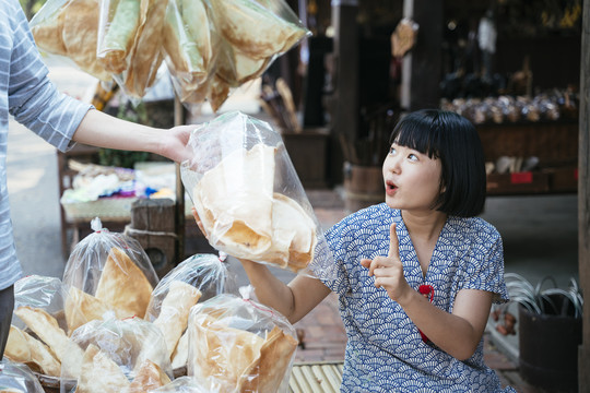 生态旅游——游客在街市上从当地可爱的小贩那里买虾、脆饼干。