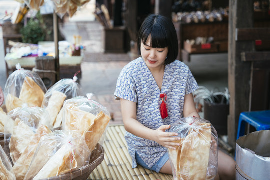 生态旅游——游客在街市上从当地可爱的小贩那里买虾、脆饼干。