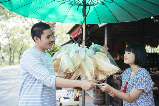 生态旅游——游客在街市上从当地可爱的小贩那里买虾、脆饼干。