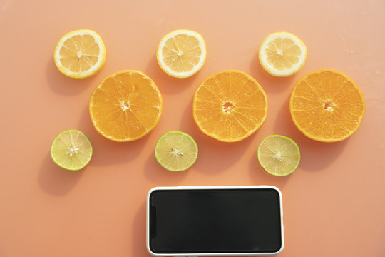 可以用智能手机在橙色背景上切水果。