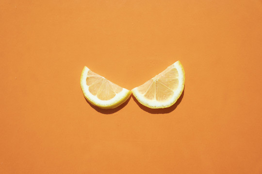 在橙色背景上放一片柠檬片和酸橙。