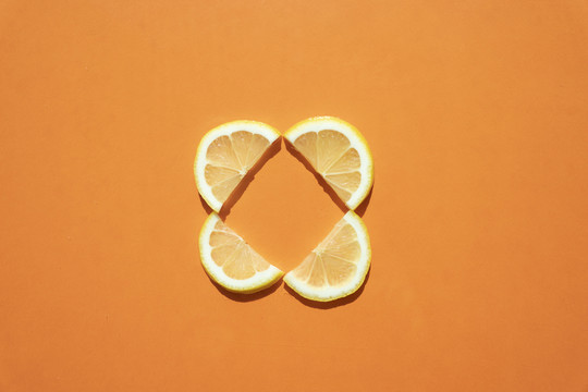 在橙色背景上放一片柠檬片和酸橙。