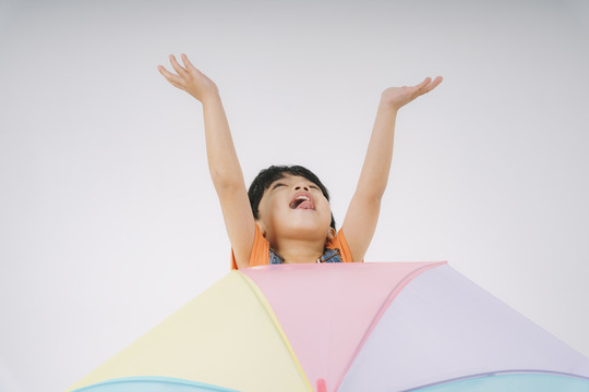 小男孩得到彩色粉彩雨伞时很高兴，他很喜欢雨伞。