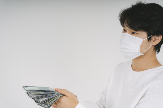 一个戴着白面具生病的人拿着很多钱来换取好的药物和治疗。是医疗费。