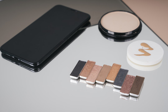 化妆品调色板色调模板，粉扑罐，和智能手机上的镜子表。