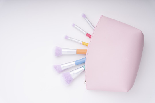 顶视图-粉彩彩虹彩色画笔内粉红色包白色背景。