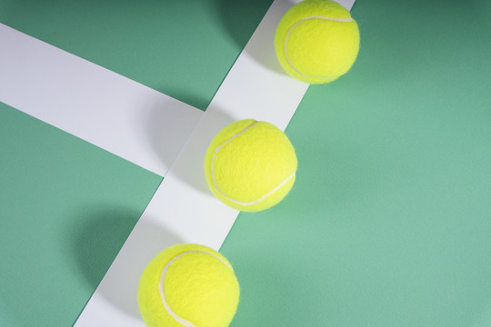 顶视图-绿色球场上的三个网球。运动概念。