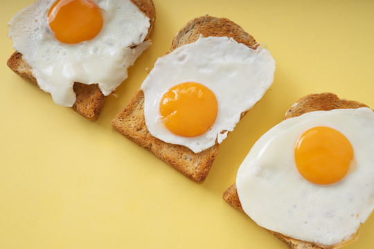 三个自制的有机切片面包烤架，上面有煎蛋。