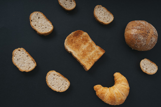 俯视图-一组黑色背景上的多种面包。