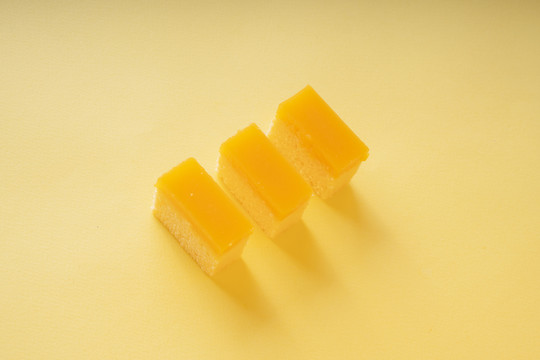 顶视图-黄色背景上的三块橙色蛋糕。