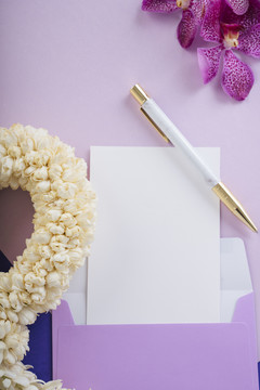 白色泰国花环，紫色背景上有茉莉花。模型纸。泰国母亲节。
