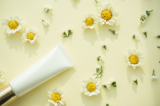 天然产物。奶油乳液瓶模拟花和叶。自然的感觉。