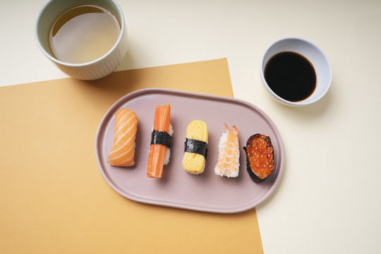 顶视图-日本寿司放在一个盘子里，配上酱油和热茶。