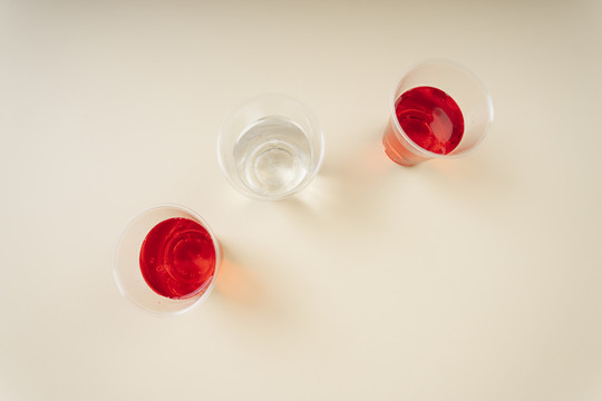 顶视图-塑料杯中的淡水和红色苏打水。