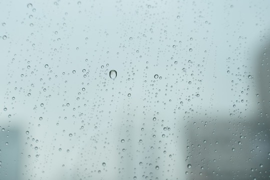 雨滴落在窗户玻璃上，在暴风雨中。乌云的景色。