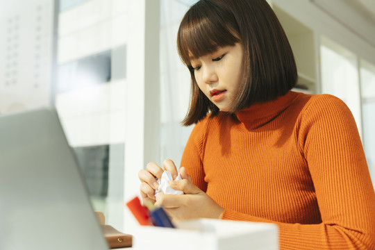 美丽的年轻亚泰黑人短发女子双手揉着纸。