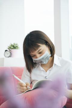 泰国大学生戴口罩在家中研究covid-19在家爆发。新常态。