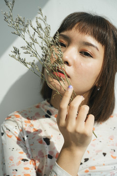 美丽的女人短发亚洲持有内稃植物白色背景。
