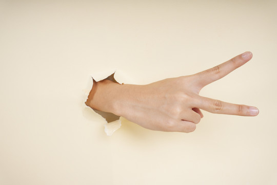 在白色背景上显示两个手指或胜利手势的女性手。