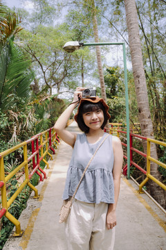 美丽的年轻亚泰女游客在乡间摆出照相机的姿势。曼谷当地之旅。