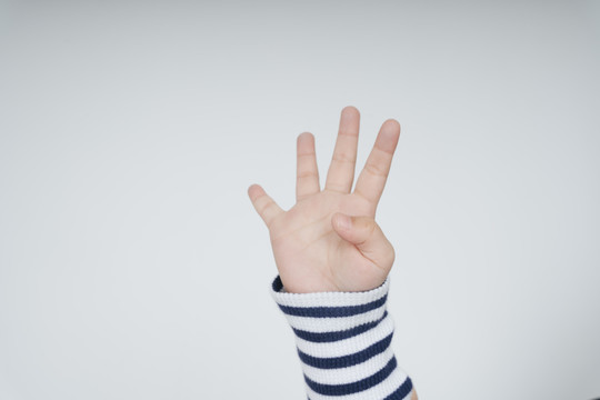 四指小孩的手在白色背景上做手势。