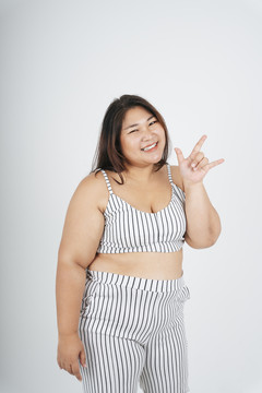 健康的亚洲胖乎乎的女人和我爱你的姿势在白色背景上的肖像。
