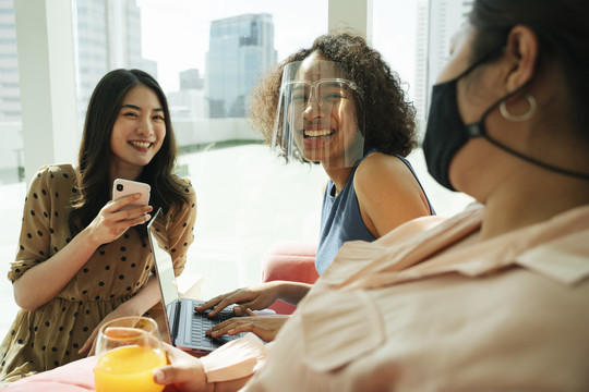 非洲女人戴着面罩在房间里和人说话。