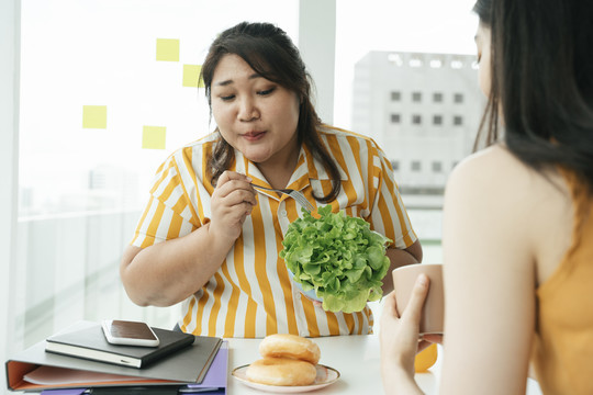 胖女人第一次在办公室尝试吃健康的沙拉。